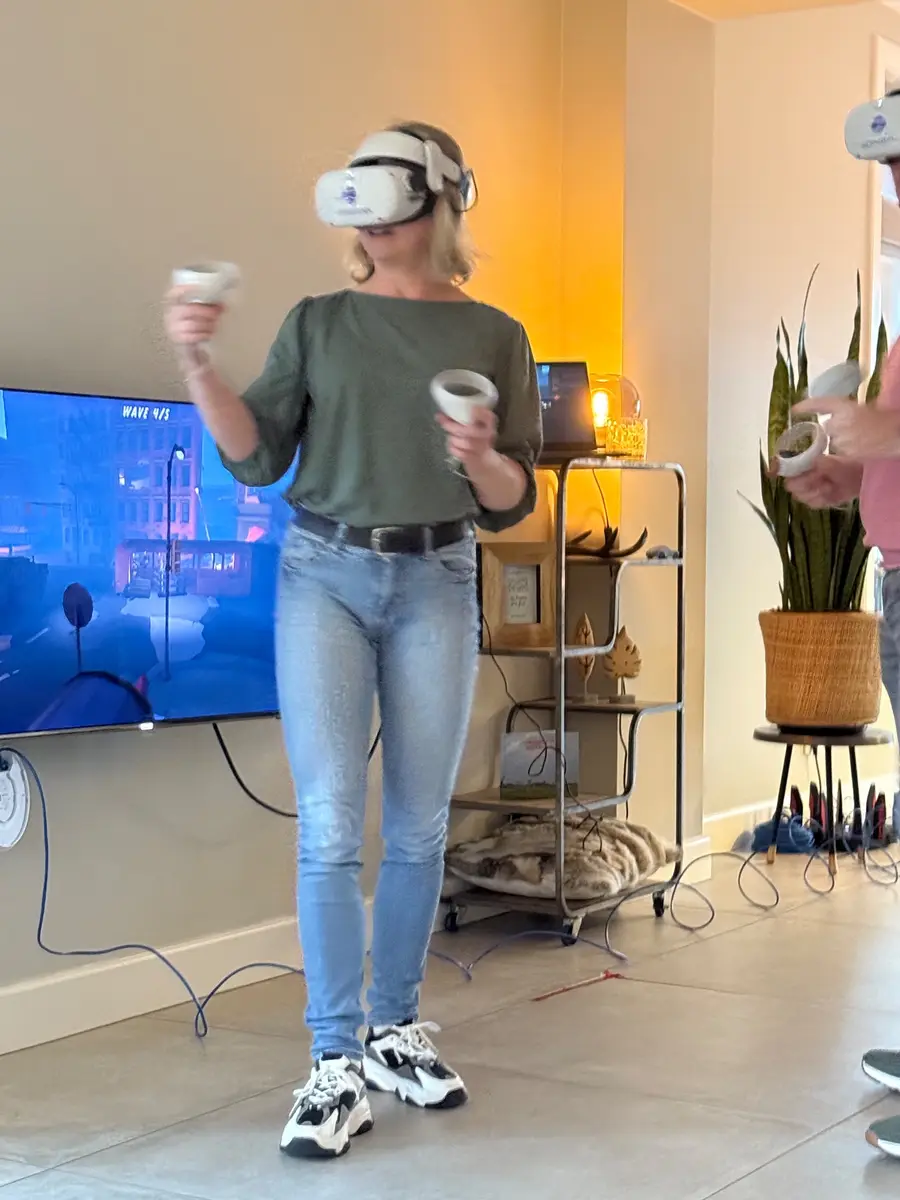 Speelster met VR-bril voor een tv-scherm in een lounge