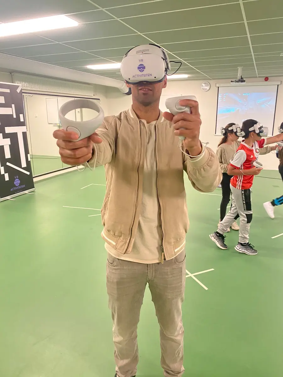 Speler met VR-bril in een sporthal met groene vloer