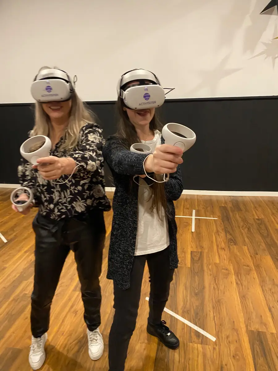 Twee speelsters met VR-bril richten hun controllers naar voren