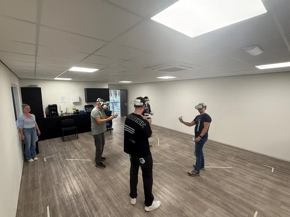 Dezelfde kantine met de VR-arena: tafels aan de kant, spelers met VR-brillen op de vrije vloer